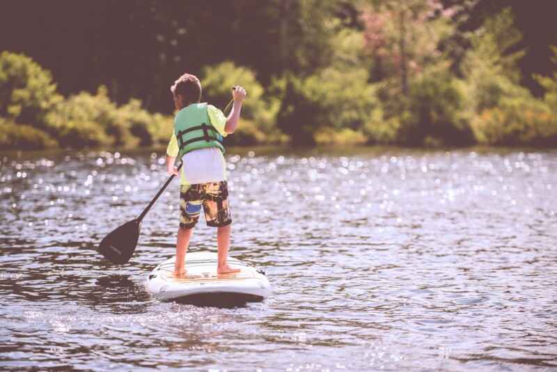 child paddle boarding on a lake