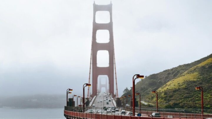 traffic on suspension bridge in fog